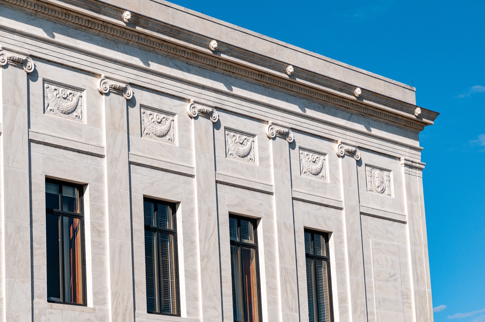 Neoclassical courthouse facade against a clear blue sky.