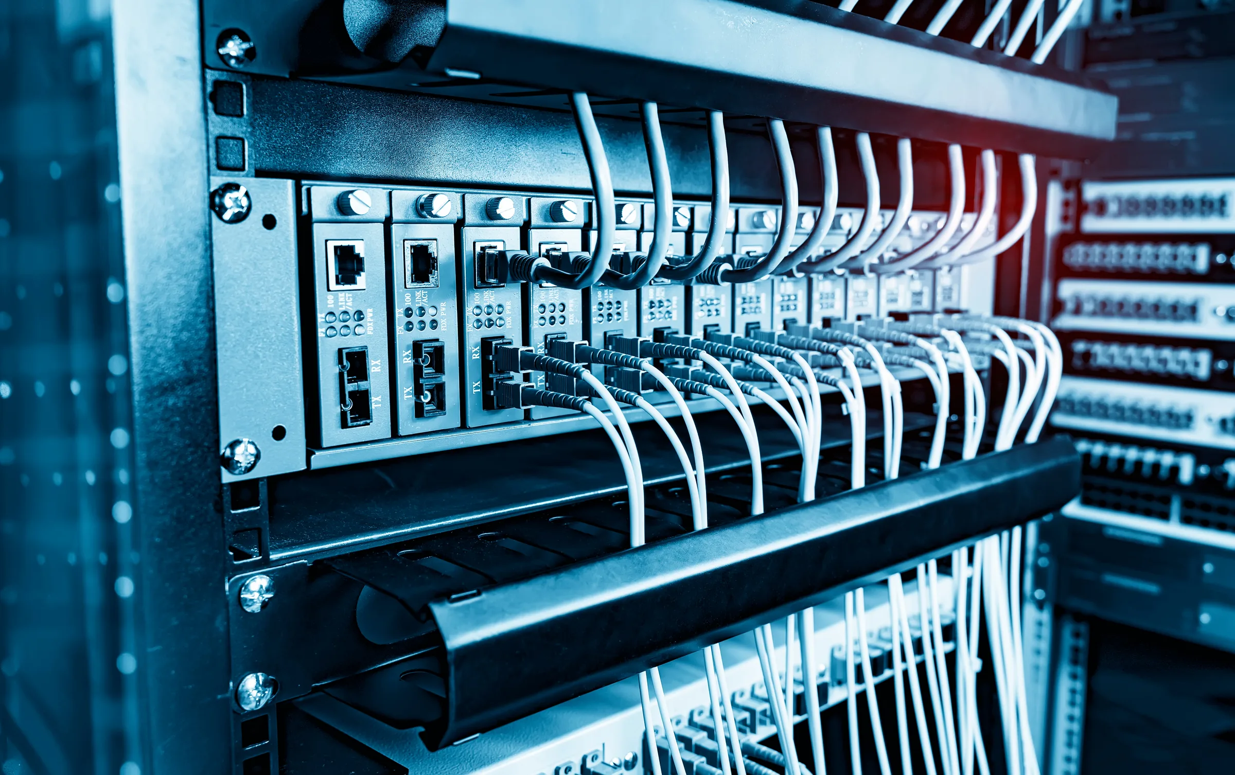 Fiber optic cables connected to network switch ports — network infrastructure financing