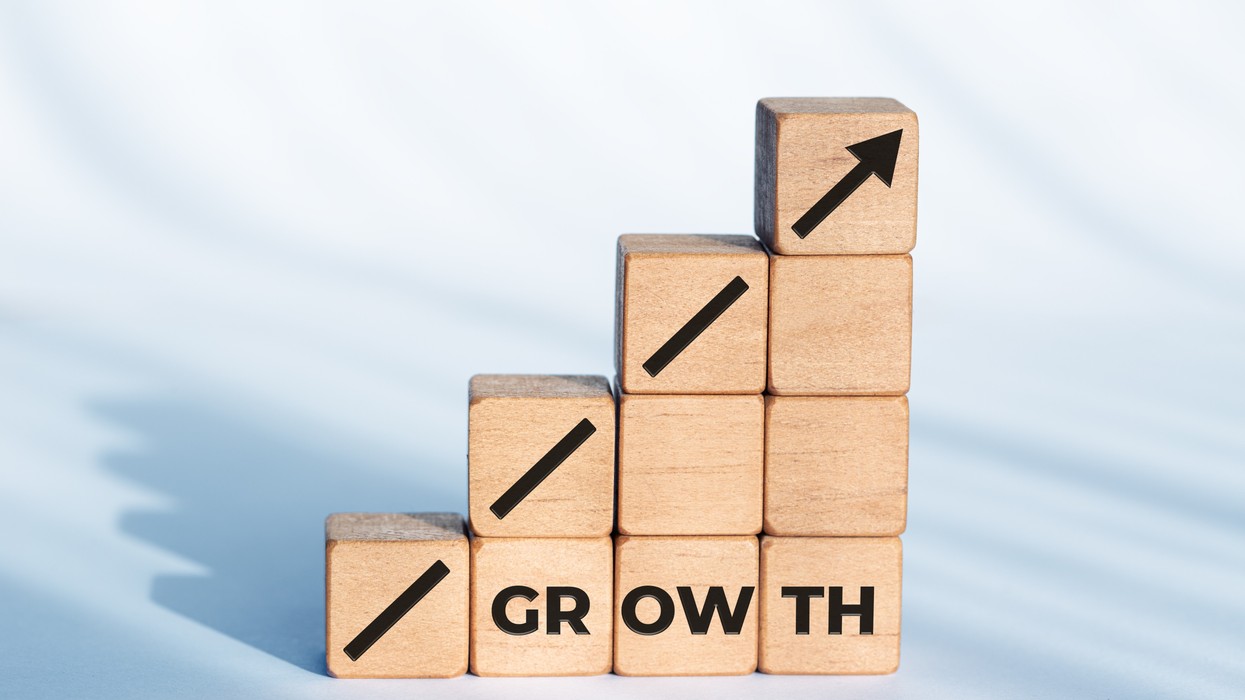 Wodden blocks stacked as a rising bar chart symbolizing business growth and financial performance.