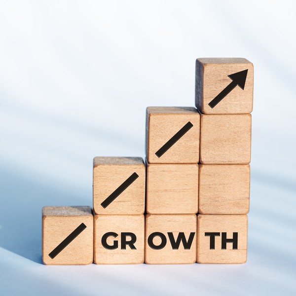 Wodden blocks stacked as a rising bar chart symbolizing business growth and financial performance.
